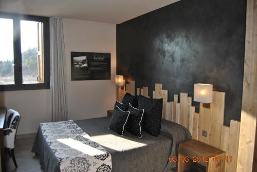 a bedroom with a bed with a wooden headboard at Santa Bárbara in Sant Corneli de Cercs 