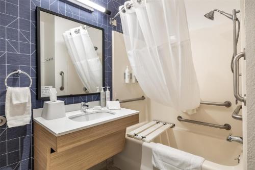 a bathroom with a sink and a toilet and a mirror at Spark by Hilton La Crosse Onalaska in Onalaska