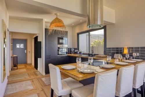 a kitchen and dining room with a table and chairs at Le Moma by the ocean in Trois Bassins