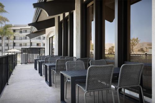 a row of chairs and tables on a balcony with windows at Homewood Suites by Hilton Santa Maria in Santa Maria