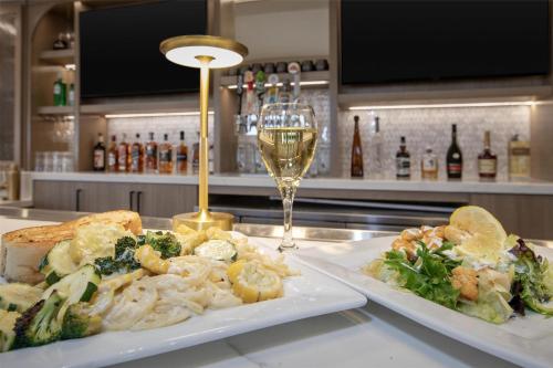 two plates of food on a counter with a glass of wine at Homewood Suites by Hilton Santa Maria in Santa Maria