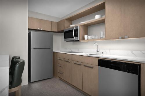 a small kitchen with a sink and a refrigerator at Homewood Suites by Hilton Santa Maria in Santa Maria