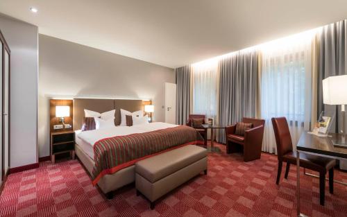 コー​​ブルクにあるTrip Inn Stadthotel Coburgのベッドとデスクが備わるホテルルームです。