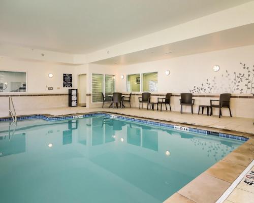 a pool with chairs and tables in a hotel at Sleep Inn & Suites Fort Scott in Fort Scott