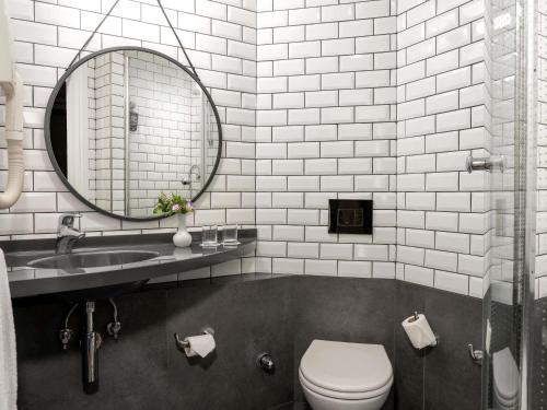 Un baño con lavabo, inodoro y espejo. en Ibis Istanbul Zeytinburnu, en Estambul