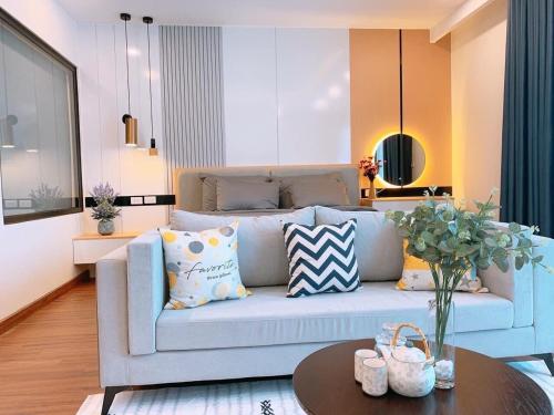 a living room with a blue couch and a table at FLC Sea Tower Quy Nhơn- View Biển in Quy Nhon