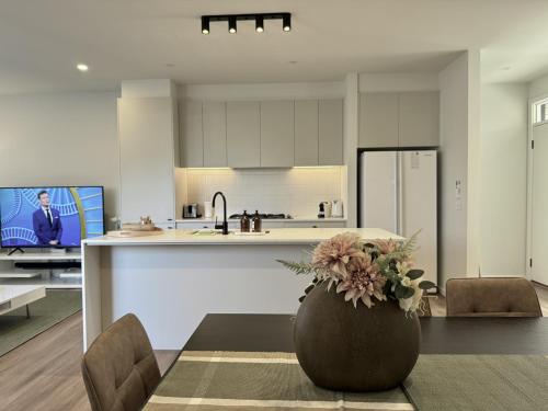 a kitchen with a vase with flowers on a table at Aalto Retreat 2 - Chic Modern Close to Everything in Rosebud