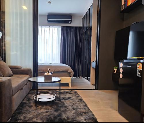 a living room with a couch and a table at Free Airport Pick Up ! 12th Floor Cozy Studio Room, 5 mins walk to IconSiam & BTS in Bangkok