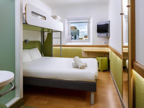 a small room with a bed and a window at ibis budget Manchester Salford Quays in Manchester