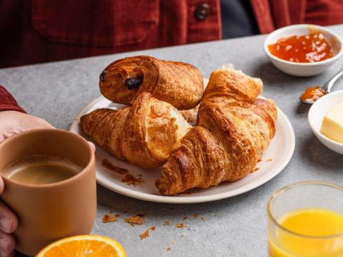 a plate of pastries on a table with a cup of coffee at ibis budget Manchester Salford Quays in Manchester