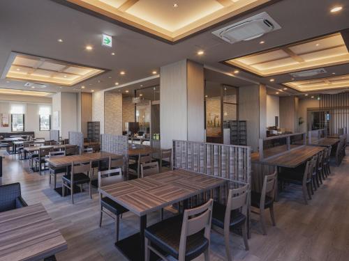 a dining room with wooden tables and chairs at Hotel Route Inn Kyoto Kumiyama in Kyoto