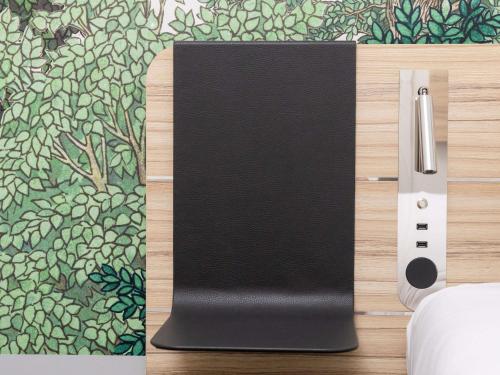 a black notebook sitting on top of a wooden wall at Novotel Suites Montpellier Antigone in Montpellier