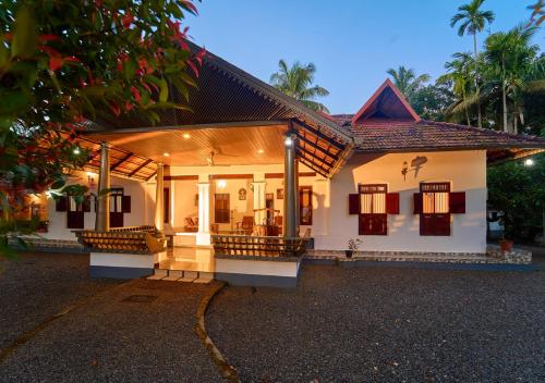 a small white house with a pathway in front of it at Cotelac Heritage Lake Resort by VOYE HOMES in Alleppey