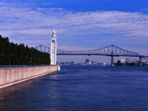 a bridge and a clock tower next to a river at Novotel Montréal Aéroport in Dorval