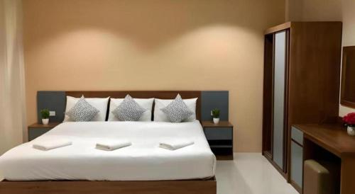 a bedroom with a large white bed with pillows at Regent Room Hotel in Suratthani