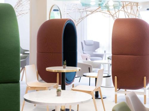 a row of tables and chairs in a room at Novotel Suites Montpellier Antigone in Montpellier