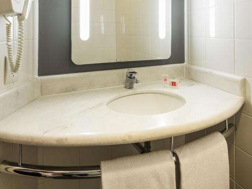 a bathroom with a sink and a mirror at ibis Sao Jose dos Campos Colinas in São José dos Campos