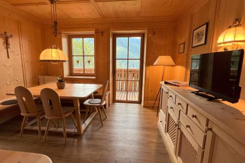 Un comedor con una mesa y un televisor. en Valentin36 Apartment Geisler, en Funes