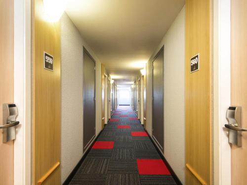 a long hallway with a red and black floor at ibis Sao Jose dos Campos Colinas in São José dos Campos