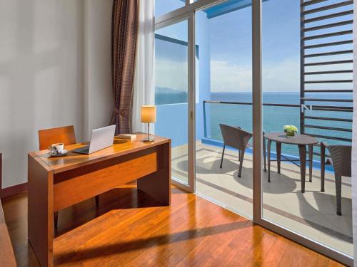 an office with a desk and a table with a laptop at Novotel Nha Trang in Nha Trang