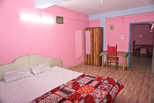 a pink bedroom with a bed and a chair at Entire 1BHK & 2BHK private apartments with personal kitchen, 767ooo54oo, TAJ RESIDENCY Holiday Homestay in Jorhat