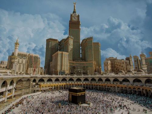a large crowd of people in a city with a clock tower at Pullman ZamZam Makkah in Makkah