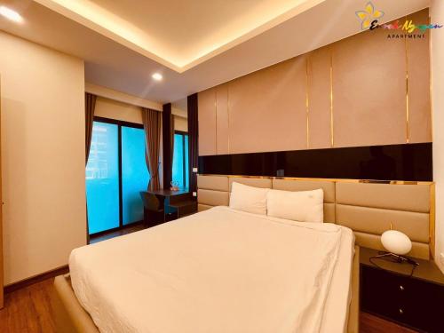 a bedroom with a white bed and a large window at FLC Sea Tower Quy Nhơn- View Biển in Quy Nhon