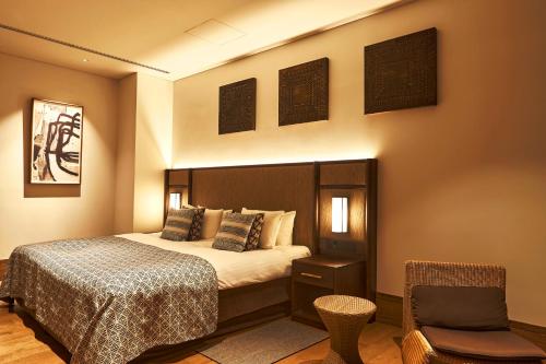 a hotel room with a bed and a chair at UMITO Okinawa Onnason in Onna