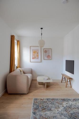 a living room with a couch and a tv at Nestkoje - Ihr Ferienzuhause für Groß & Klein in Neustadt an der Weinstraße