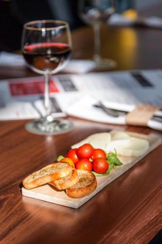 a plate of food on a table with a glass of wine at Novotel Monterrey Valle in Monterrey