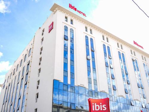 un bâtiment avec une enseigne au sommet dans l'établissement Ibis Tunis, à Tunis