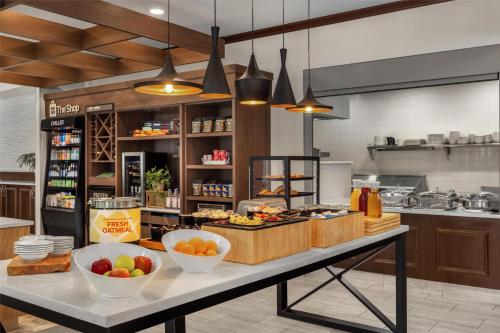 een keuken met een tafel met kommen eten erop bij Hilton Garden Inn Ames in Ames