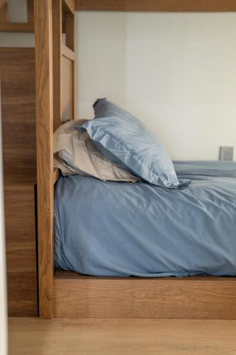 a bed with blue sheets and pillows on it at Avanti in Santa Maria