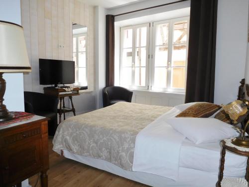 une chambre avec un lit, une télévision et une fenêtre dans l'établissement Location 