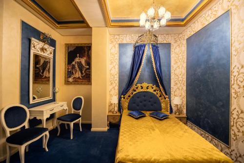 a bedroom with a gold bed with a desk and chairs at Belle Epoque Boutique (Adult Only) in Constanţa