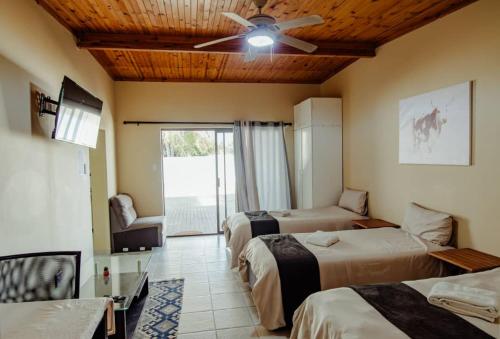 a hotel room with two beds and a ceiling fan at NJ SKY GUESTHOUSE & BOUTIQUE windhoek in Windhoek