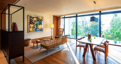 a living room with a table and chairs and a room withwindows at UMITO Okinawa Onnason in Onna