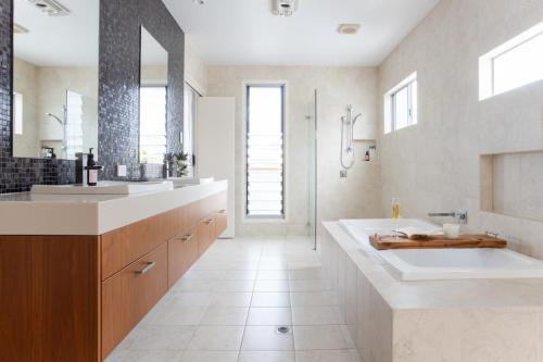 a bathroom with a large tub and a sink at Solara in Kingscliff