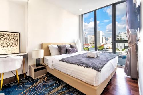 a bedroom with a large bed and a large window at Hyde Sukhumvit 11 Bangkok in Bangkok