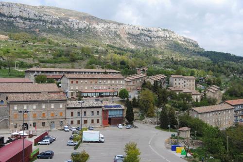 a town with cars parked in a parking lot in front of a mountain at Santa Bárbara in Sant Corneli de Cercs 