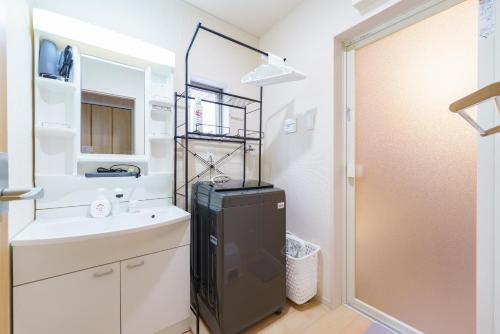 ein kleines Badezimmer mit Waschbecken und Kühlschrank in der Unterkunft Nagoya15min 6 beds Free Parking 3BR 13guests 100sqm in Nagoya