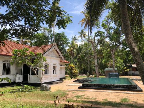 a house with a swimming pool in the yard at Casa Del Ceylon in Hikkaduwa