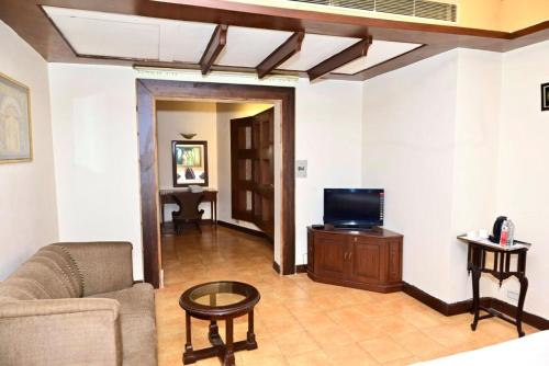 a living room with a couch and a tv at Hotel Metro Regency Meerut in Meerut