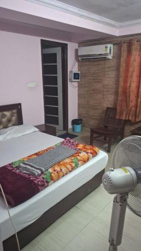 Un dormitorio con una cama y una silla en una habitación. en BS Residency, en Dehradun