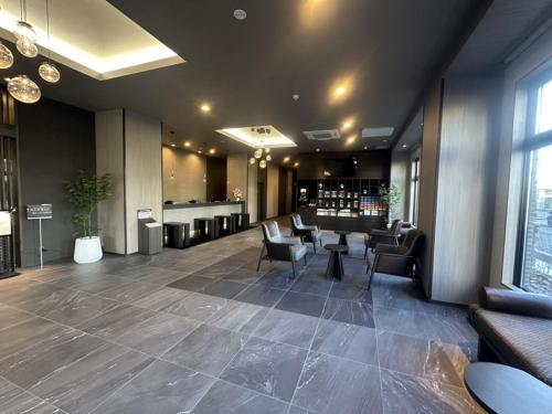 a lobby with chairs and a bar in a building at Hotel Route Inn Grand Moriya Ekimae in Moriya