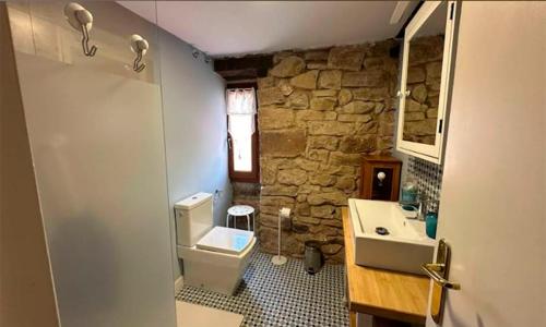 a stone bathroom with a sink and a toilet at Hotel Rural Casa de Las Campanas in Salinas de Pisuerga