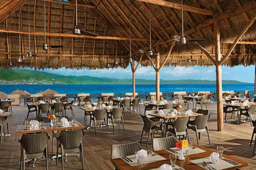 a restaurant on the beach with tables and chairs at Sunscape Puerto Vallarta Resort in Puerto Vallarta
