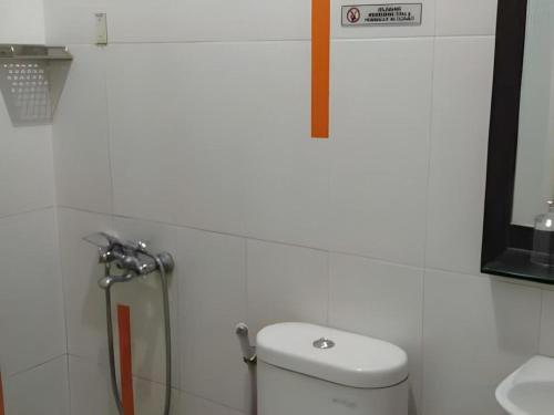 a bathroom with a toilet and a sink at Hotel Ahava in Magelang