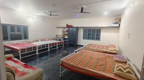 una habitación con tres camas en una habitación en RoHans FarmStay and Events, en Wangāpalli