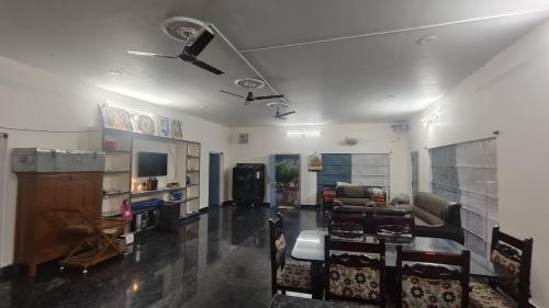 sala de estar con ventilador de techo y sofá en RoHans FarmStay and Events, en Wangāpalli
